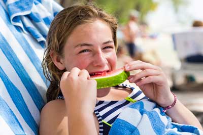 Girl eating watermelon, healthy summer foods for kids

