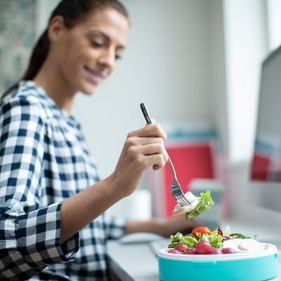 Woman eating a quick, healthy lunch at work.